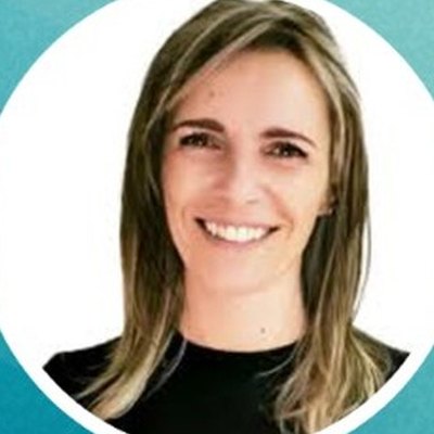 Andreia Ferreira, de cabelo comprido com madeixas louras e camisola preta, sorri sobre fundo branco.