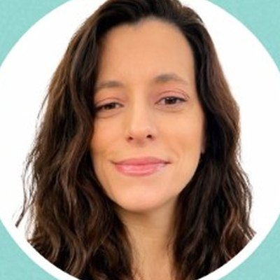 Retrato de Catarina Antunes, de cabelo castanho comprido e ondulado, com um sorriso discreto, sobre fundo branco.